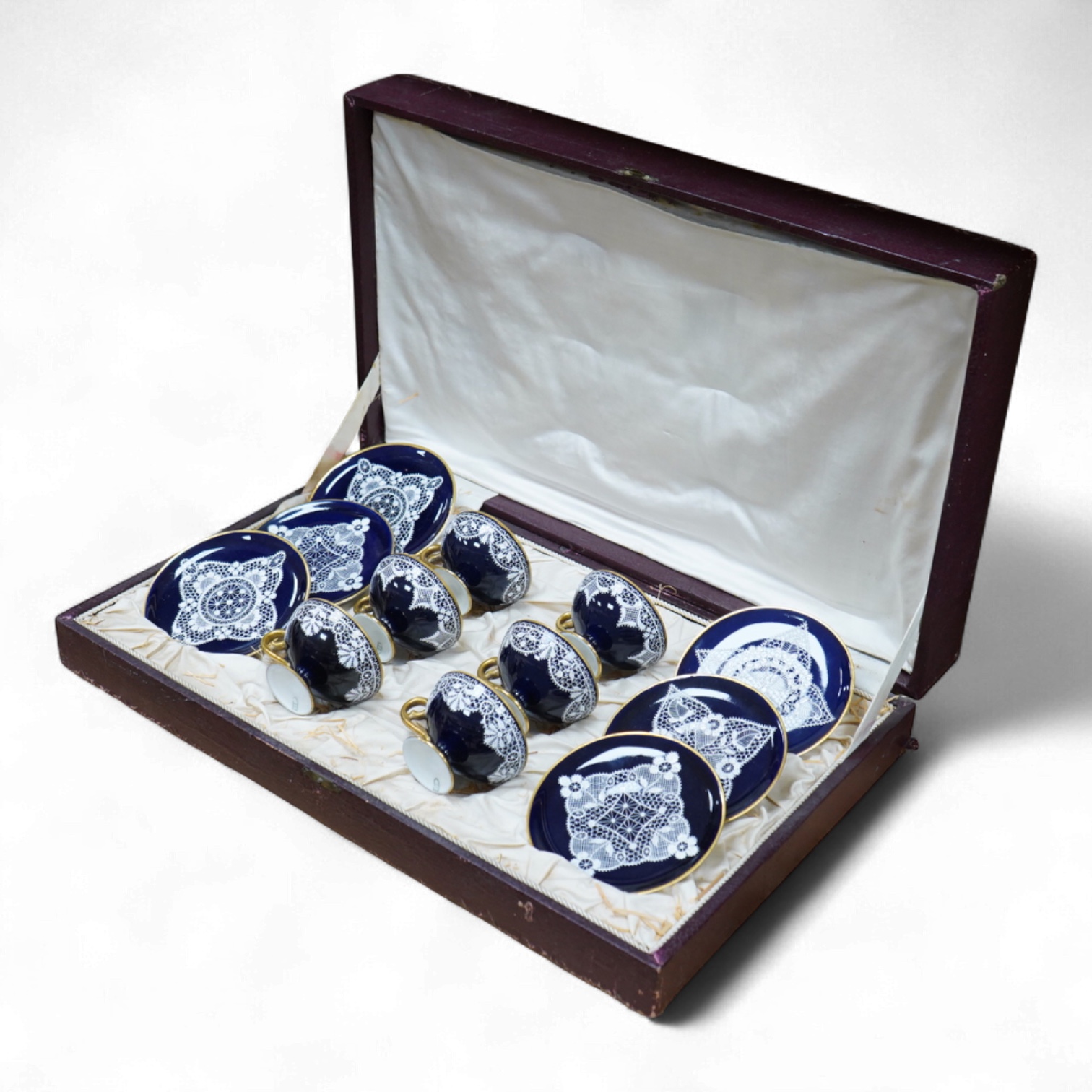 A Vienna-style lace-pattern coffee set, Beehive marks, cased